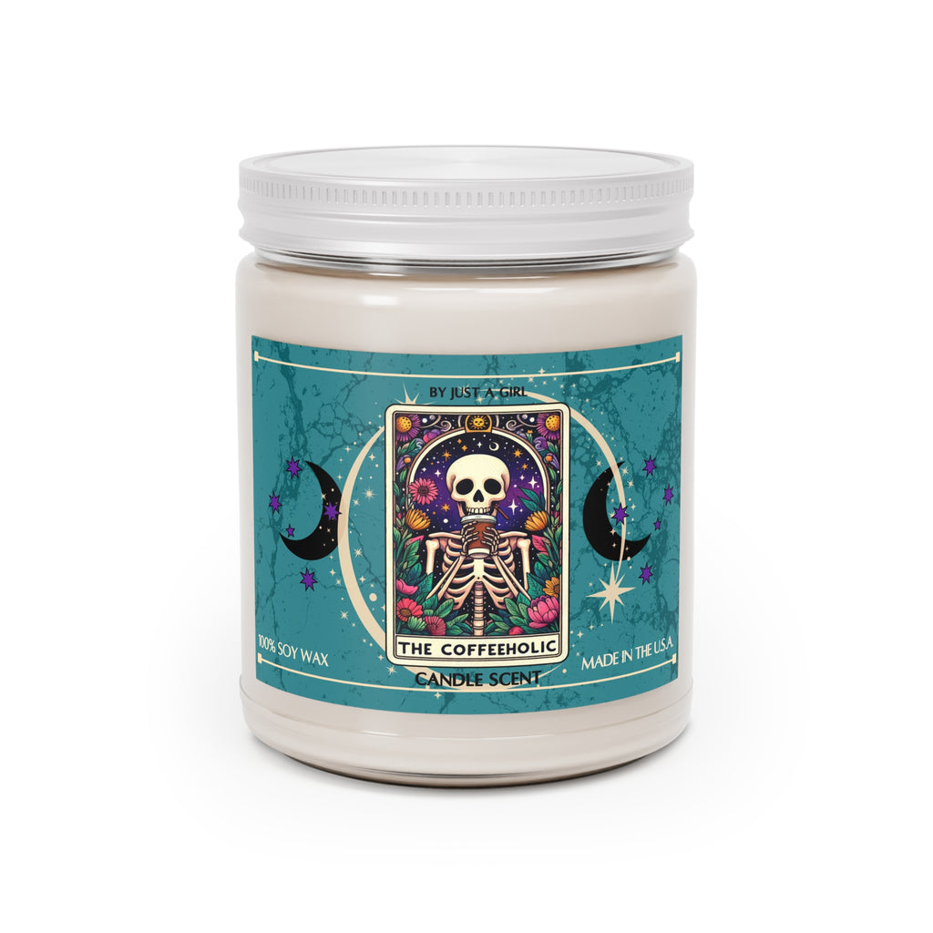 Eine weiße Kerze in einem durchsichtigen Glasgefäß mit weißem Deckel. Das Etikett ist türkisblau mit Mond- und Sternmotiven und zeigt in der Mitte eine goldgerahmte Illustration. Darauf ist ein sitzendes Skelett zu sehen, das eine Tasse Kaffee trinkt, umgeben von bunten Blumen und unter einem sternenklaren Nachthimmel mit einem Halbmond. Der Text auf dem Etikett lautet "BY JUST A GIRL".