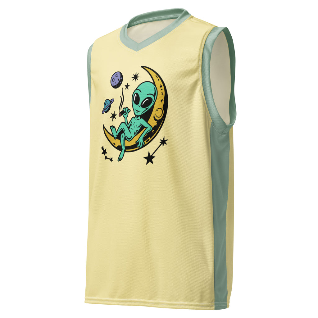 Ein lebhaftes, sonnengelbes Basketballtrikot, akzentuiert durch frische, mintgrüne Streifen an den Seiten und am Kragen. Das Herzstück des Trikots ist eine skurrile Grafik: Ein grünes Alien, entspannt auf einer leuchtenden, gelben Mondsichel, mit einer Zigarette im Mundwinkel. Um den Mond herum tanzen stilisierte Sterne und Planeten, die dem Design eine kosmische Note verleihen.
