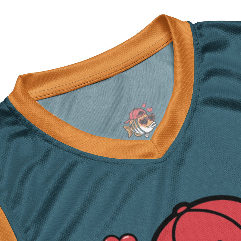 Ein dunkelpetrolfarbenes Basketballtrikot mit leuchtend orangefarbenen Seitenstreifen und Kragen. Mittig auf der Brust ist eine charmante Cartoon-Figur eines gestreiften Fisches abgebildet, der eine rote Baseballkappe verkehrt herum und herzförmige Sonnenbrillen trägt, während drei rote Herzen über seinem Kopf schweben