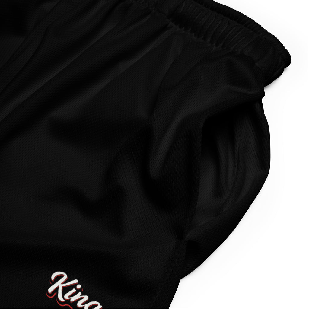 Schwarze Mesh-Sportshorts mit elastischem Bund. Am unteren rechten Bein steht in weißer Schrift mit rotem Schatten und schwarzem Rand das Wort "King".