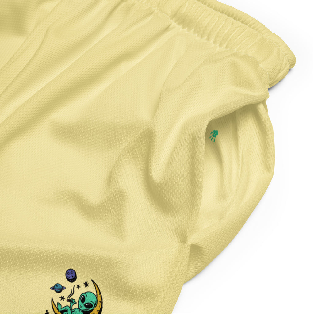 leuchtend sonnengelbe Basketballshorts, die auf dem linken Hosenbein das farbenfrohe "Chilling Vibes"-Logo mit einem grünen Alien auf einem gelben Halbmond zeigen, umgeben von Sternen und Planeten. Die Shorts bestehen aus glattem Sportmaterial.