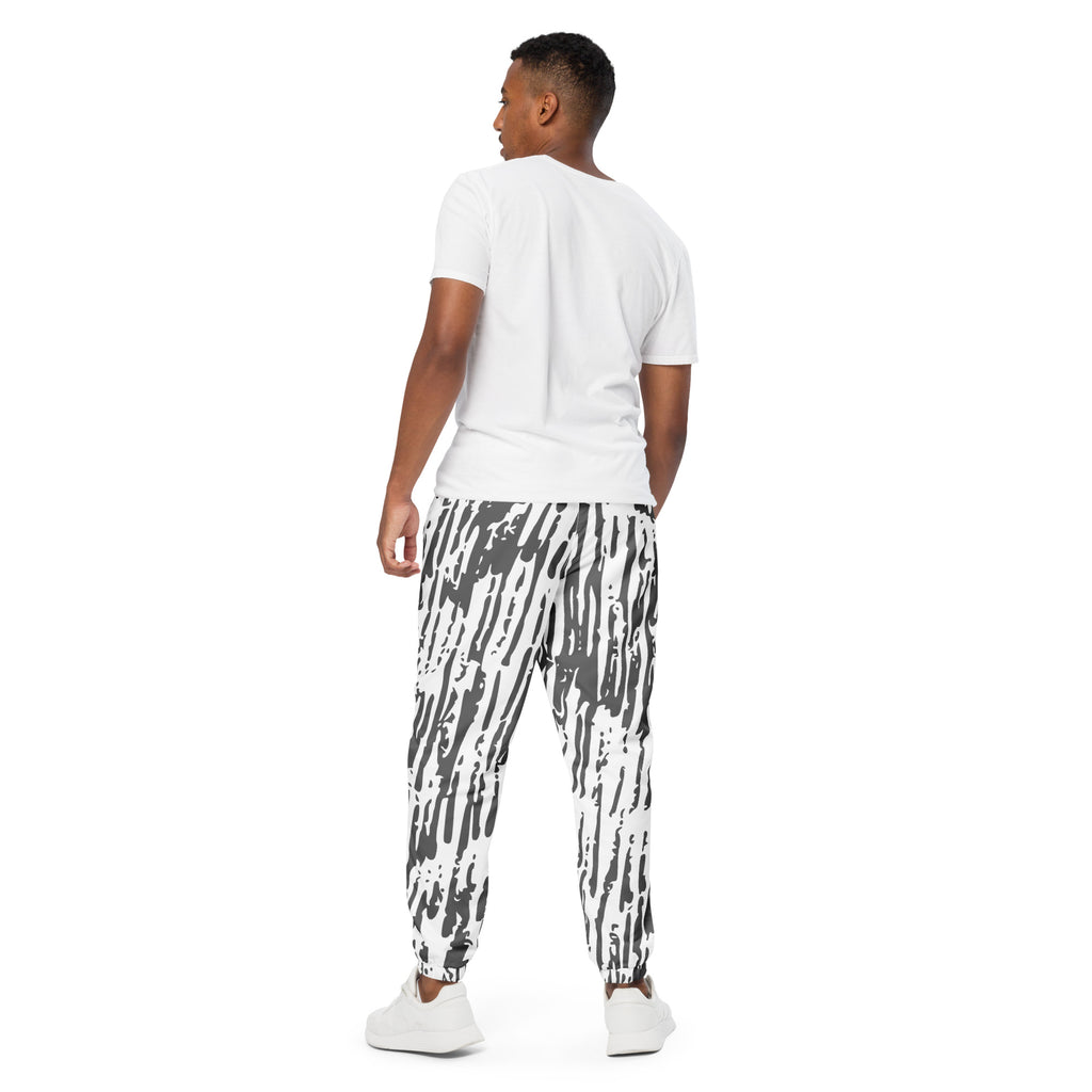 Schwarz-weiße Trainingshose mit einem abstrakten, vertikalen Strichmuster. Die Hose hat einen elastischen Bund und Bündchen an den Beinabschlüssen.