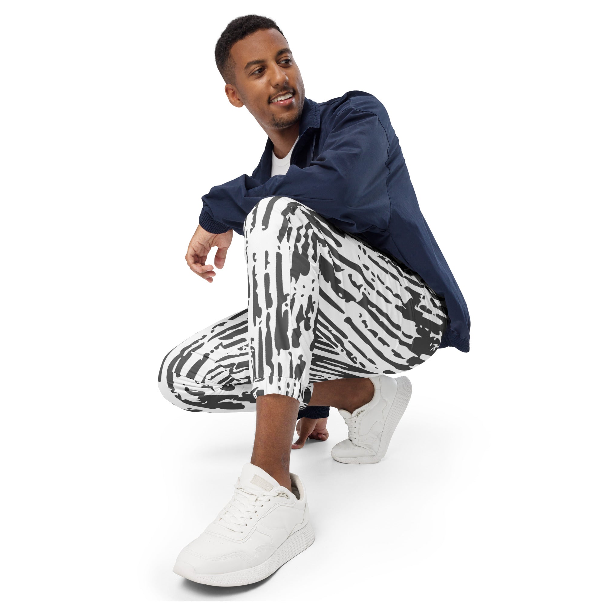 Schwarz-weiße Trainingshose mit einem abstrakten, vertikalen Strichmuster. Die Hose hat einen elastischen Bund und Bündchen an den Beinabschlüssen.