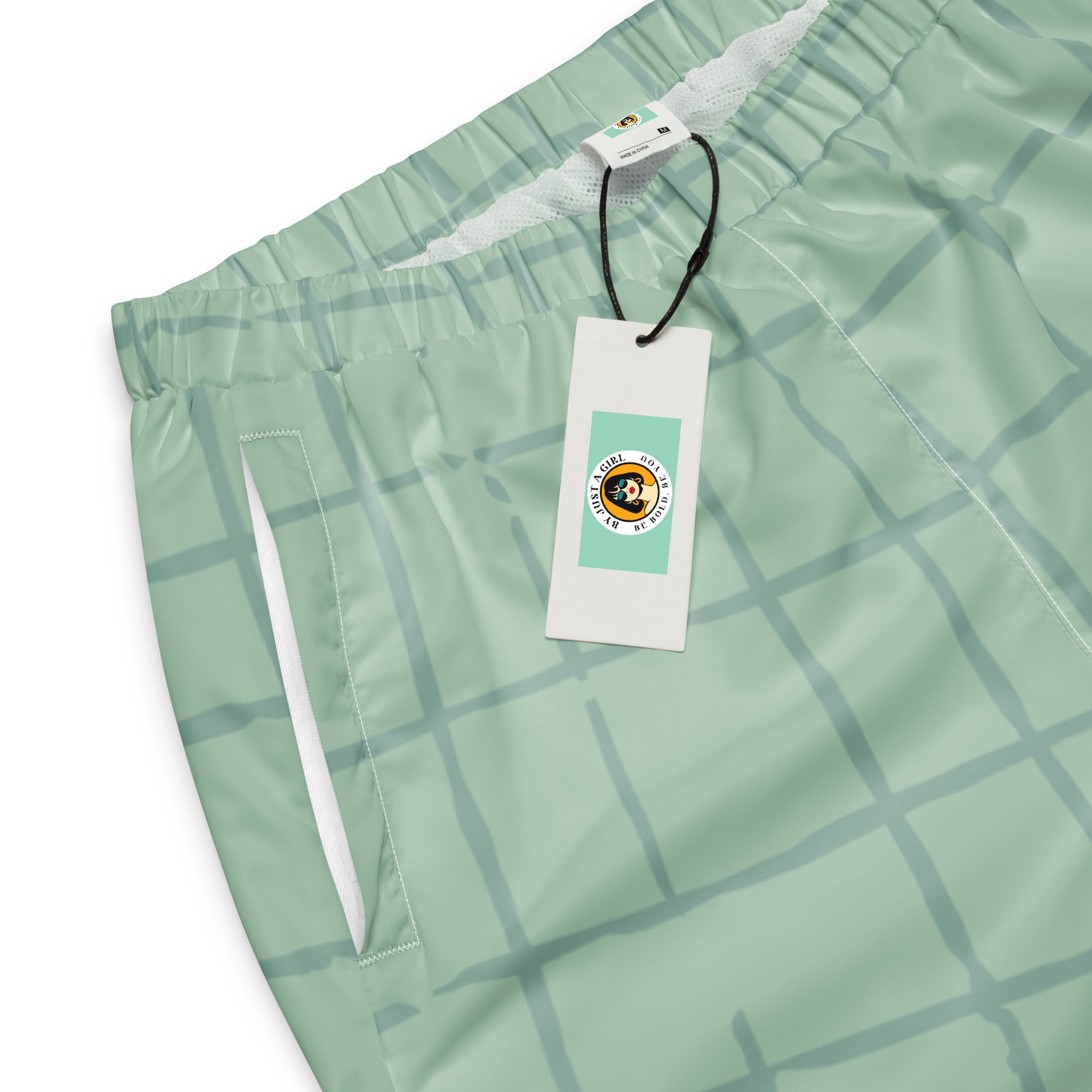 Trainingshose in hellem Mintgrün mit einem dezenten, hellgrauen Gittermuster. Die Hose hat einen elastischen Bund und Bündchen an den Beinabschlüssen.