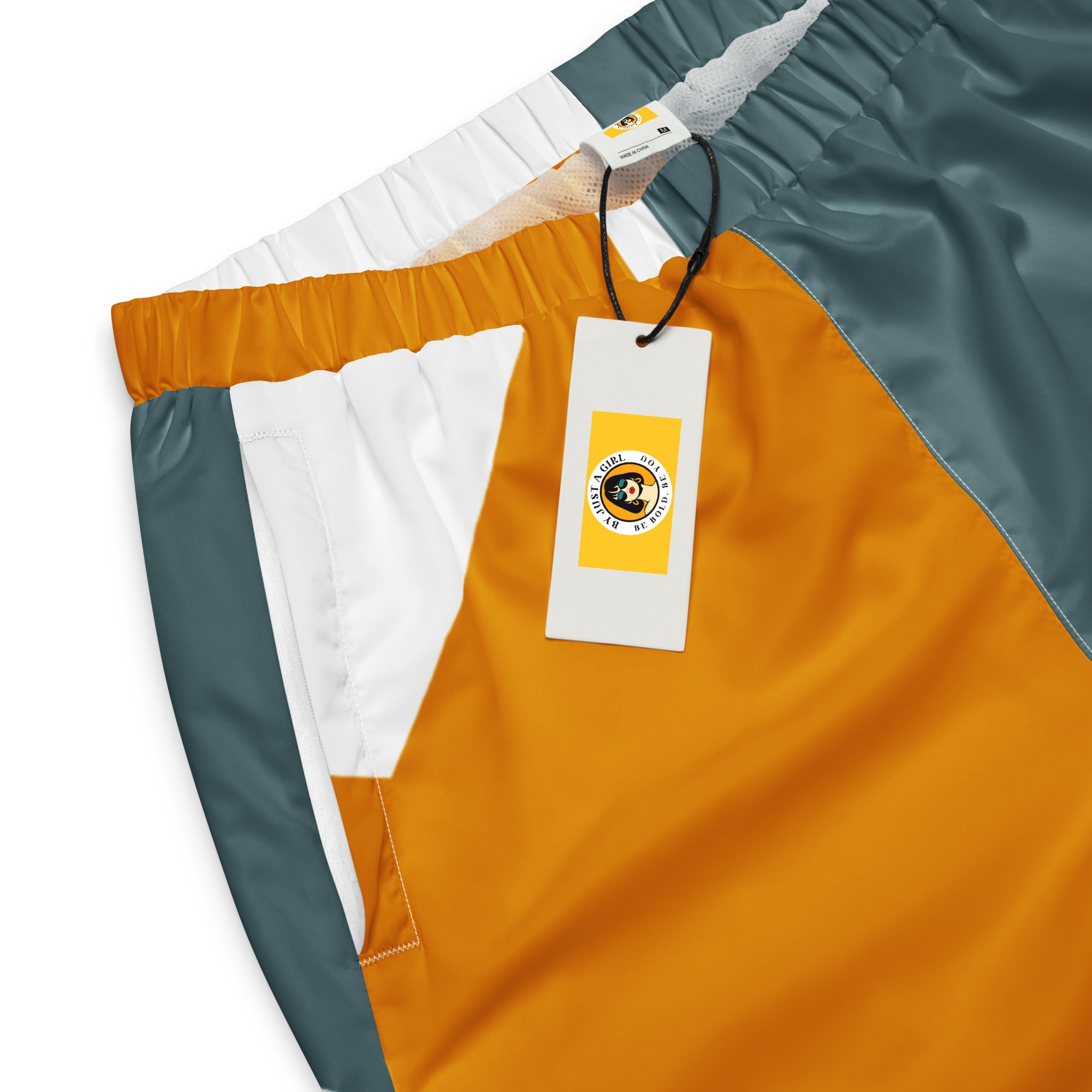 Trainingshose mit einem abstrakten, geometrischen Muster in den Farben Gelb, Grau und Weiß. Die Hose hat einen elastischen Bund und Bündchen an den Beinabschlüssen.