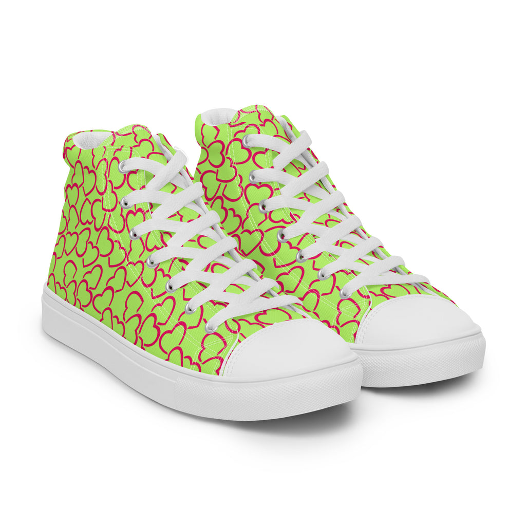Ansicht von vorne der weißen High-Top-Sneaker mit einem durchgängigen Muster aus ineinandergreifenden, neonrosa umrandeten Herzen auf einem leuchtend lindgrünen Hintergrund. Die Schnürsenkel und Zehenkappen sind weiß. Designed, by Just a Girl.