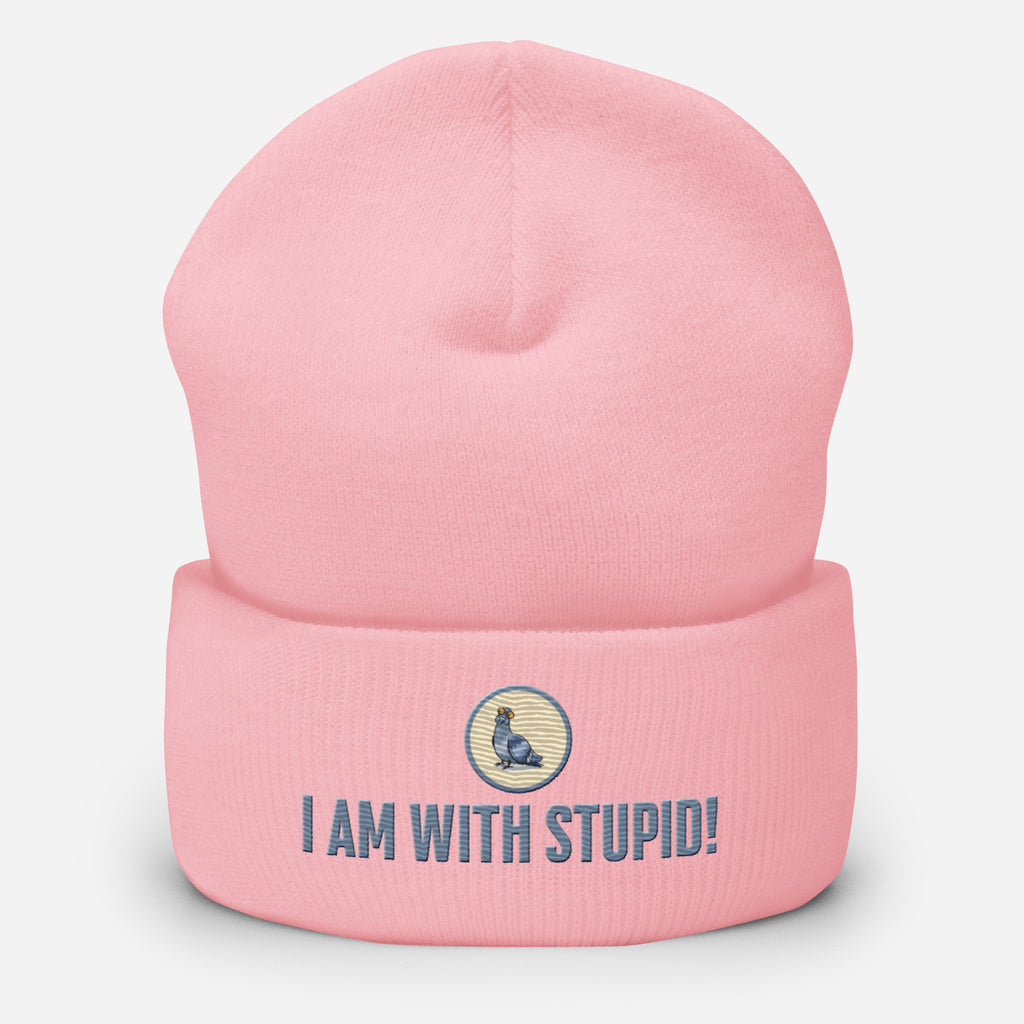 Eine Babyrosa farbene Cuffed Beanie mit aufgesticktem Patch als Taube mit einem runden beige-grauen Rahmen auf der Vorderseite. Darunter ein Schriftzug mit Grossgeschriebenen Buchstaben "I Am with Stupid!" Designed, by Just a Girl.