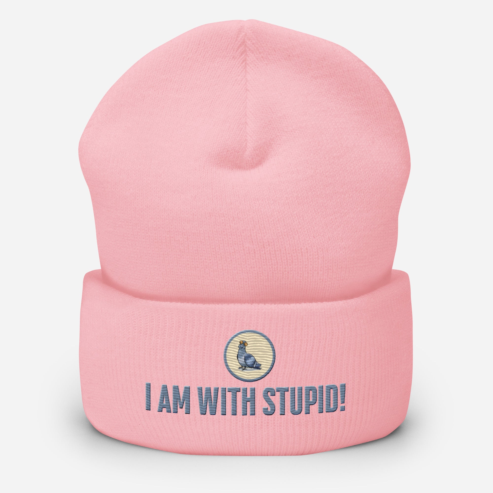 Eine Babyrosa farbene Cuffed Beanie mit aufgesticktem Patch als Taube mit einem runden beige-grauen Rahmen auf der Vorderseite. Darunter ein Schriftzug mit Grossgeschriebenen Buchstaben "I Am with Stupid!" Designed, by Just a Girl.