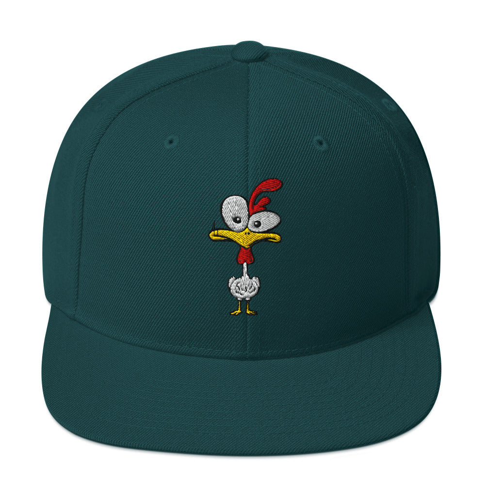 Eine klassische, farbige Snapback-Cap mit flachem Schirm. Auf der Vorderseite ist ein gesticktes Cartoon-Motiv eines Huhns zu sehen, das einen hellen Kopf, große Augen, einen farbigen Kamm und einen Schnabel sowie eine kleine stilisierte Geste am Hals hat. Der obere Teil der Kappe ist dunkel, während der Schirm und der obere Knopf eine leuchtende Kontrastfarbe aufweisen.