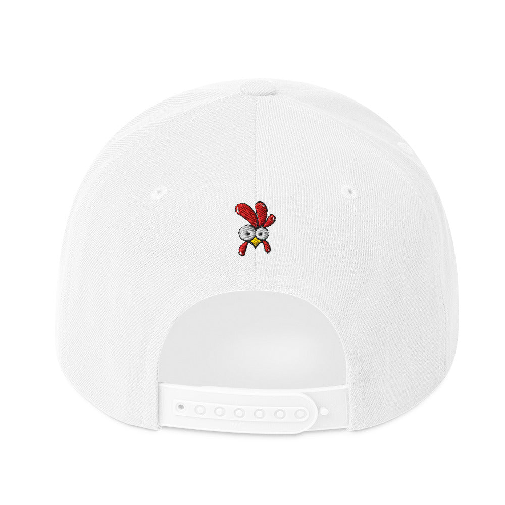 Eine klassische, zweifarbige Snapback-Cap mit flachem Schirm. Auf der Vorderseite ist ein gesticktes Cartoon-Motiv eines Huhns zu sehen, das einen hellen Kopf, große Augen, einen farbigen Kamm und einen Schnabel sowie eine kleine stilisierte Geste am Hals hat. Der obere Teil der Kappe ist dunkel, während der Schirm und der obere Knopf eine leuchtende Kontrastfarbe aufweisen.