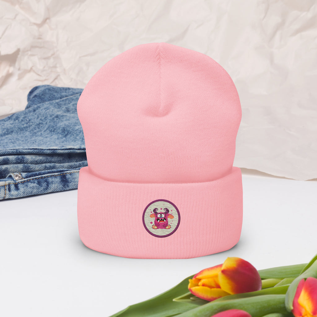 Cuffed Beanie in baby pink mit aufgesticktem, pinkem Monster-Gesicht in einem runden lila Rahmen auf der Vorderseite dekoriert mit Jeans und Blumen. Designed, by Just a Girl.