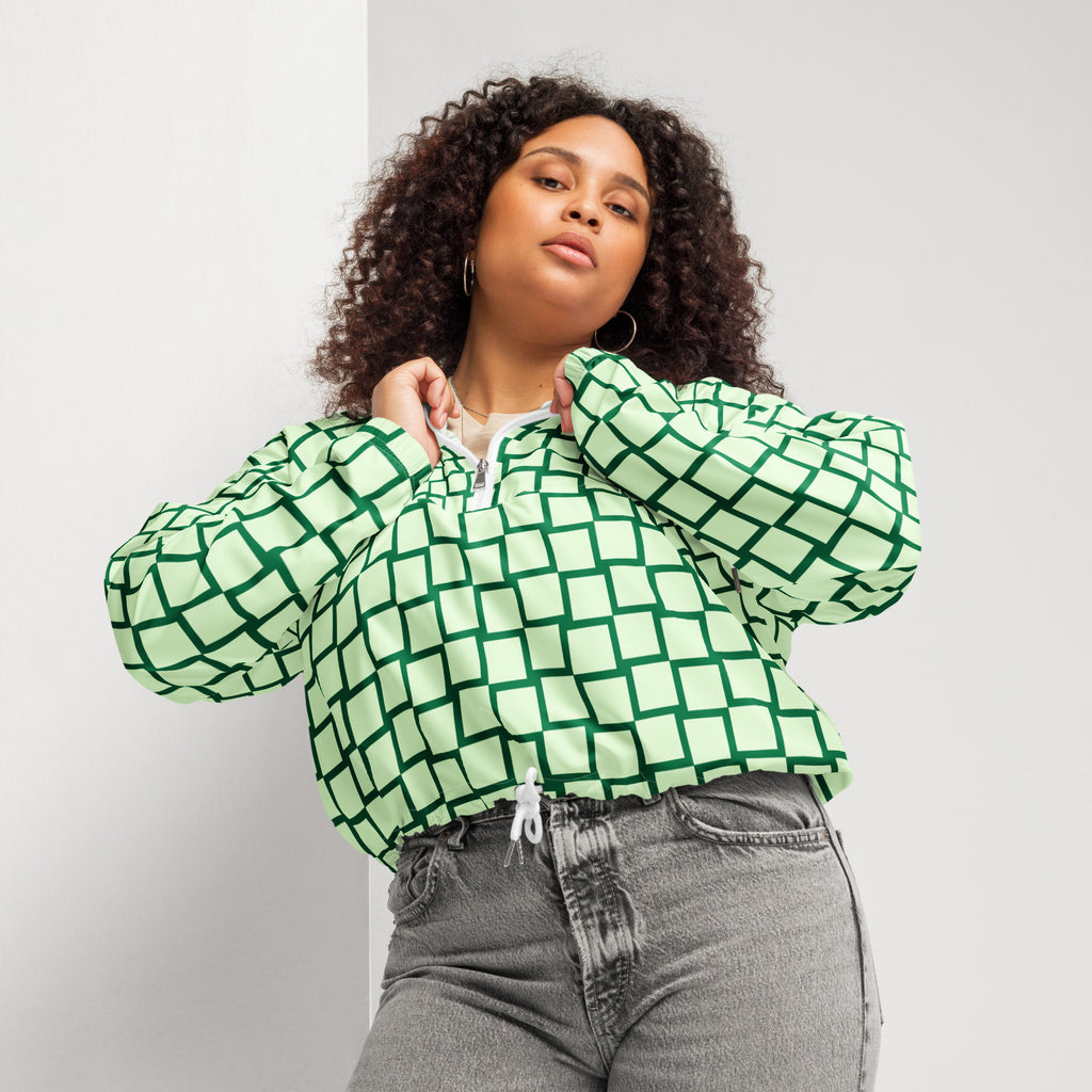 Ein Damen Cropped Windbreaker mit einem Schachbrettmuster in hellem Mintgrün und dunklem Grün. Die Jacke hat eine Kapuze, einen halben Reißverschluss mit weißen Kordeln und einen verstellbaren Saum. Mockup woman Vorderansicht. By Just a Girl.