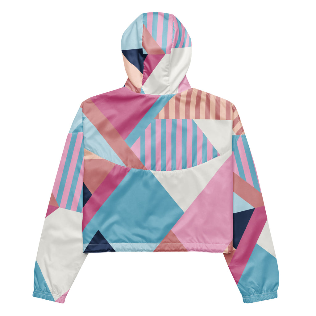 Ein Damen Cropped Windbreaker mit einem lebhaften, geometrischen Muster aus verschiedenen Dreiecken und Rechtecken in Pastellfarben wie Hellblau, Rosa, Beige, Dunkelblau und Weiß. Die Jacke hat eine Kapuze, einen halben Reißverschluss, weiße Kordeln und einen verstellbaren Saum. Jacke Rückansicht.  By Just a Girl.