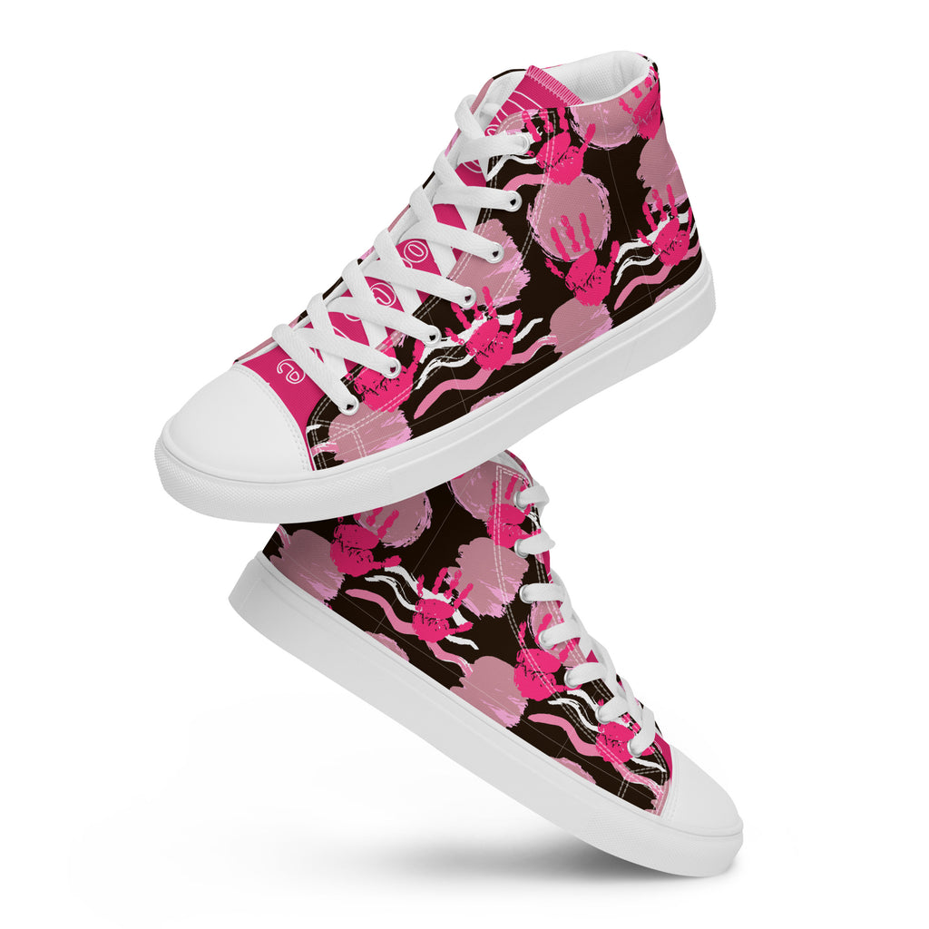 Ein Paar schwebende High-Top-Canvas-Sneaker mit einem Muster aus pinkfarbenen Handabdrücken und wellenförmigen Linien und Kreise auf schwarzem Hintergrund. Die Sohlen, Zehenkappen und Schnürsenkel sind weiß. Designed, by Just a Girl.