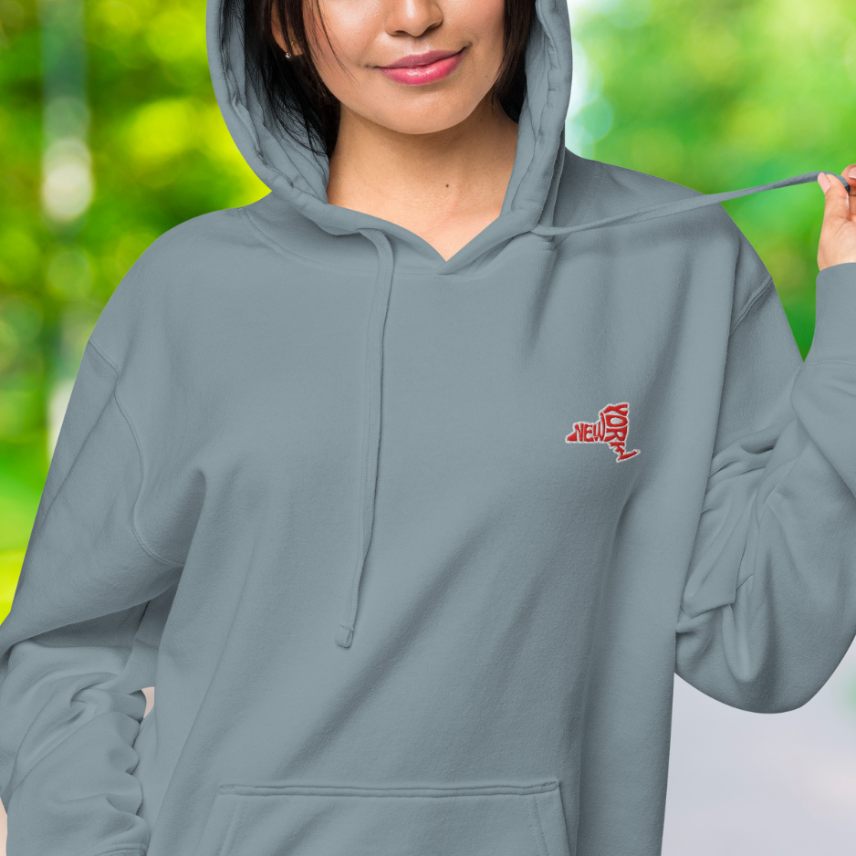 Nahaufnahme des weiblichen Models mit Sicht auf das gestickte New Yorker Emblem auf der linken Brusthöhe.