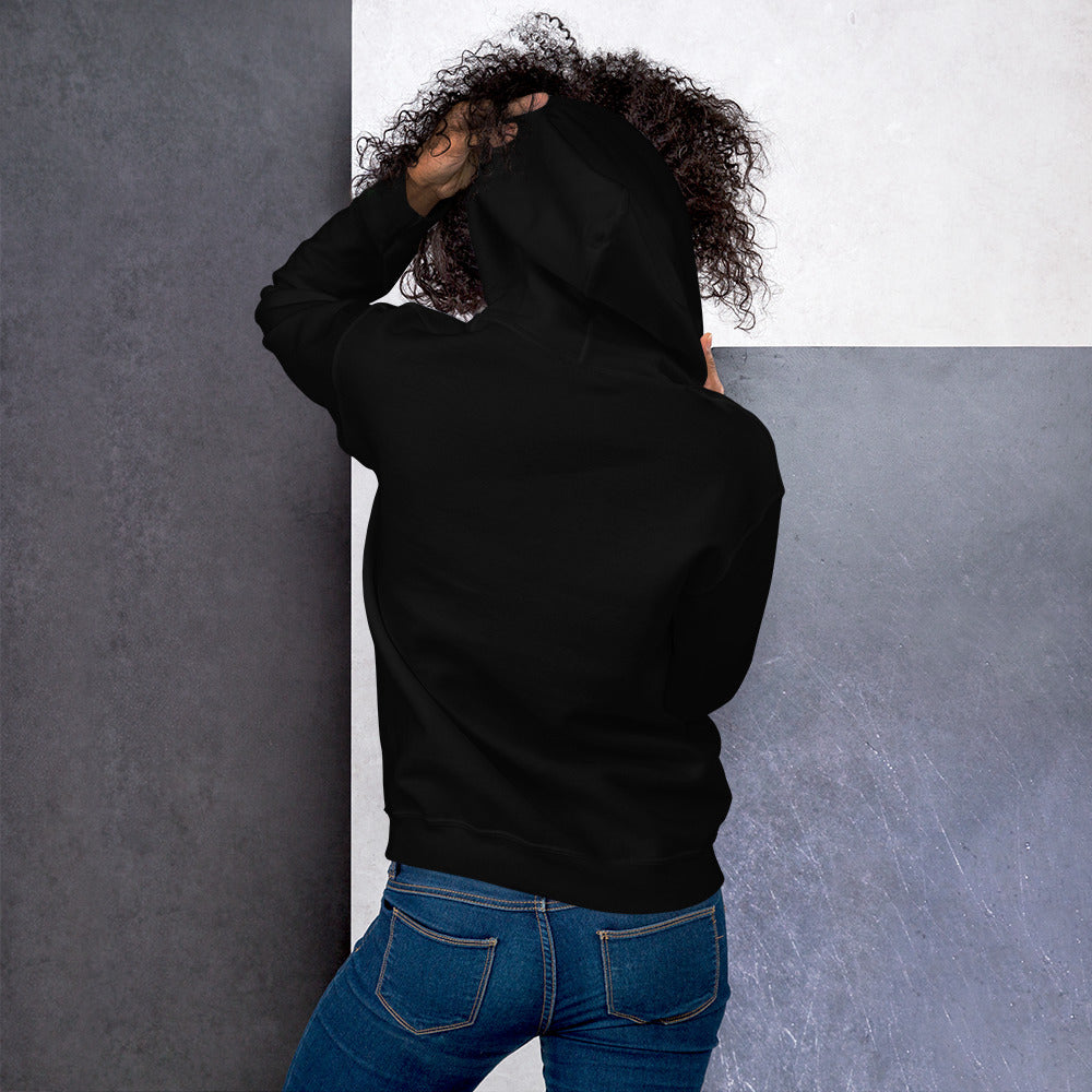 Ein weibliches Model zeigt sich von der Rückseite mit dem Kapuzenpullover "The Black One" und hält mit der linken Hand die Kapuze hoch.