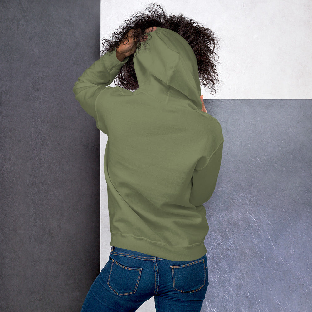 Ein weibliches Model zeigt sich von der Rückseite mit dem Kapuzenpullover "The Olive One" und hält mit der linken Hand die Kapuze hoch.