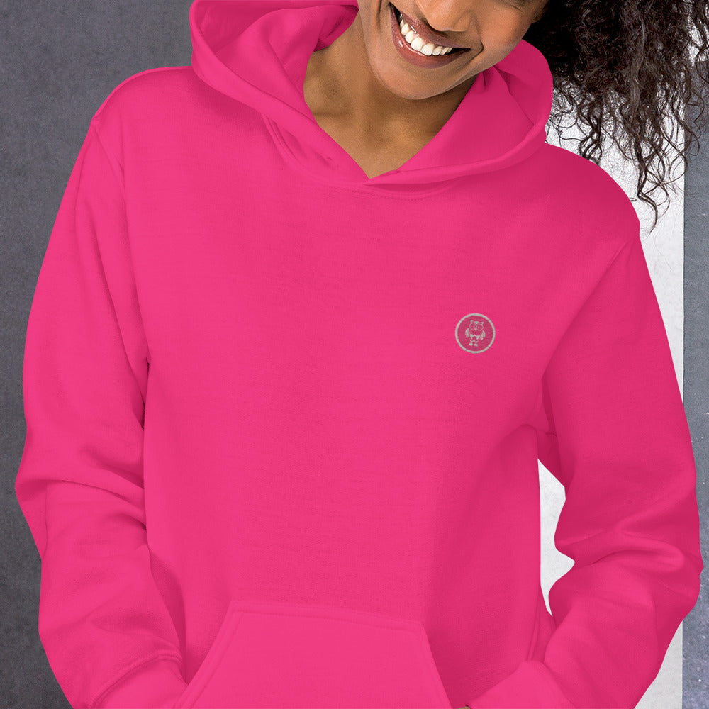 Nahaufnahme des weiblichen Models mit Sicht auf das gestickte Eulen Emblem auf der linken Brusthöhe.