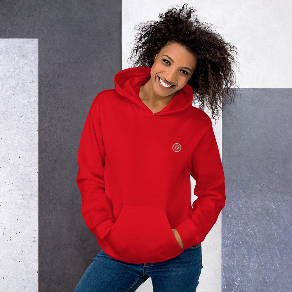 Ein weibliches Model zeigt sich mit dem Kapuzenpullover "The Poppy One" Beide Hände lässig in der vorderen Beuteltasche.