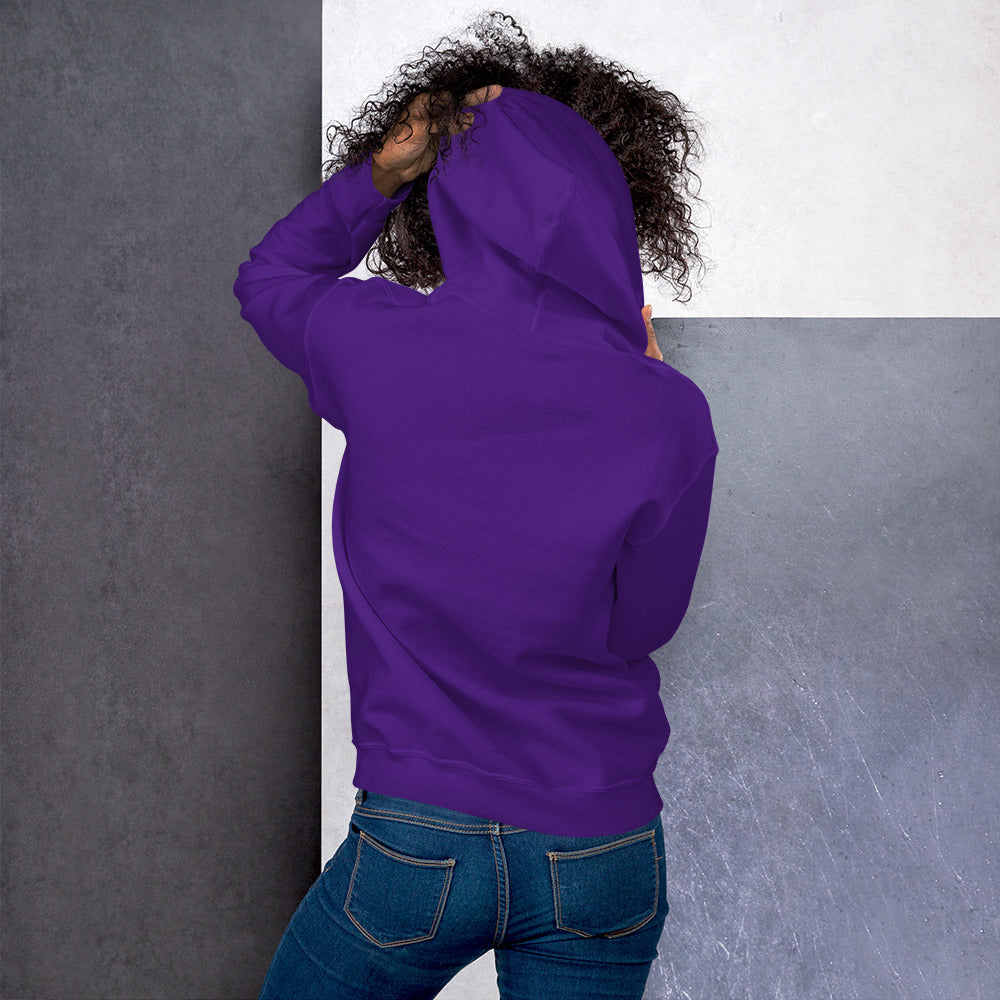 Ein weibliches Model zeigt sich von der Rückseite mit dem Kapuzenpullover "The Purple One" und hält mit der linken Hand die Kapuze hoch.