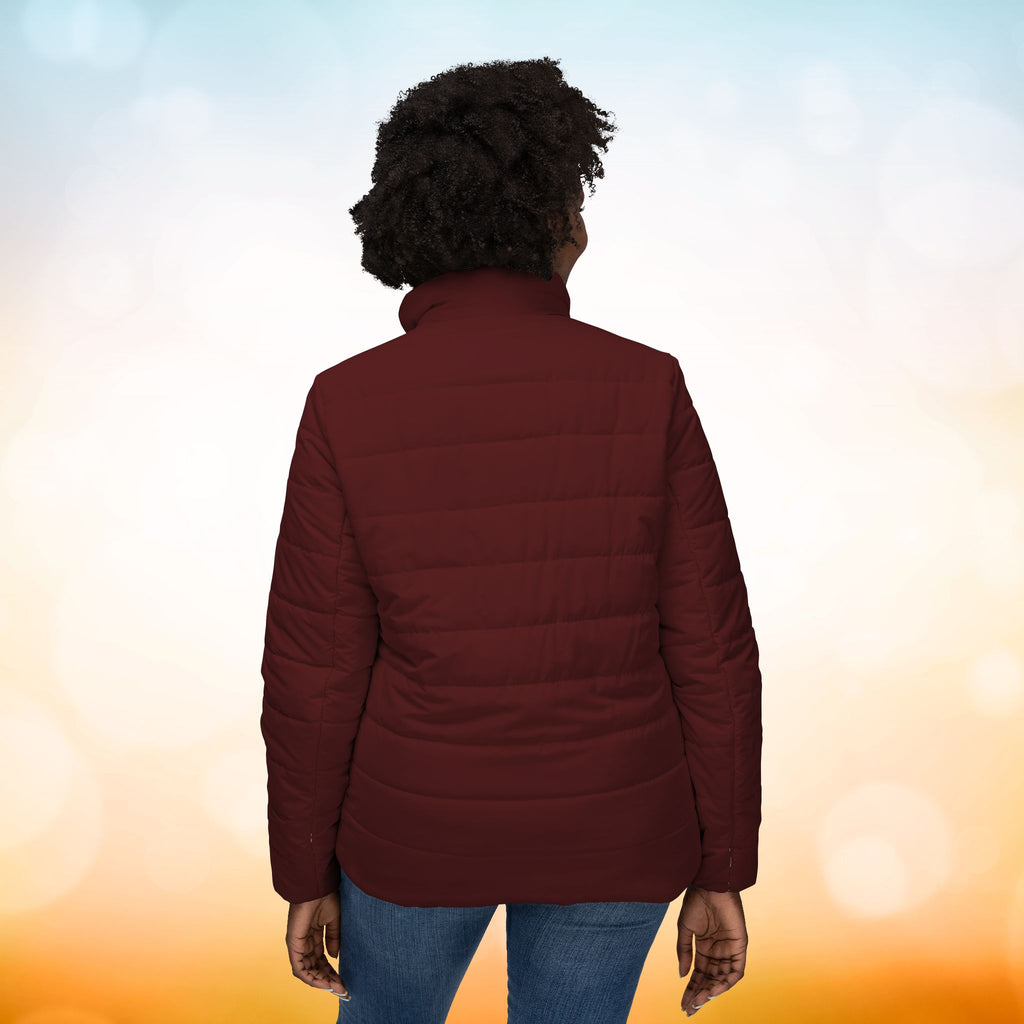 Ein weibliches Model trägt eine Damen-Pufferjacke in der Rückenansicht in einem Oxblood Farbton. Die Jacke ist horizontal gesteppt, hat eine glatte Oberfläche sowie einen hohen Stehkragen. Designed, by Just a Girl.

