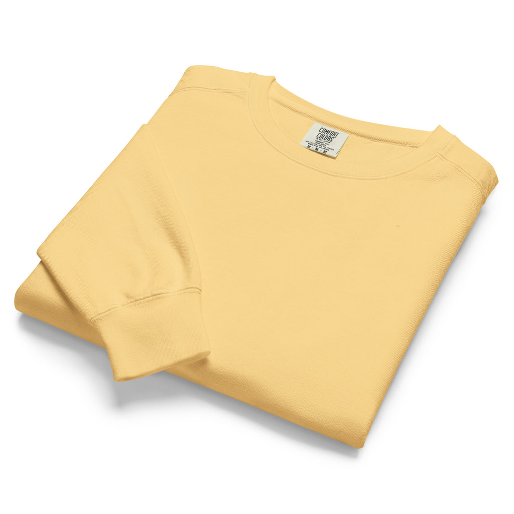 Ein unifarbener Pullover freigestellte gefaltete Ansicht in Gelb, das als Yellow Butter bezeichnet wird. Das Kleidungsstück ist schlicht und hat lange Ärmel. 