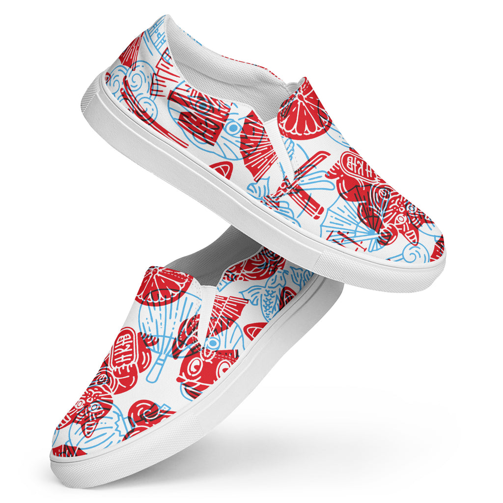 Ein Paar Damen Slip-on-Schuhe mit einem Muster aus traditionellen asiatischen Motiven in Rot und Hellblau. Auf den Schuhen ist die ikonische Maneki Neko winkende Katze abgebildet. Die Schuhe schweben vor einem weißen Hintergrund. Designed, by Just a Girl