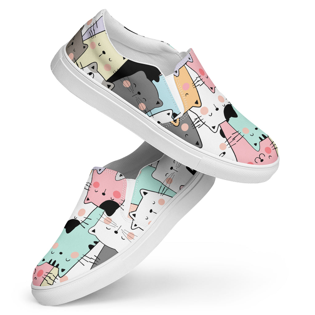Ein Paar Damen Slip-on-Schuhe mit einem Muster aus stilisierten, farbigen Katzen in Grau, Rosa, Orange, Mintgrün und Weiß. Die Schuhe schweben vor einem weißen Hintergrund. Designed, by Just a Girl.