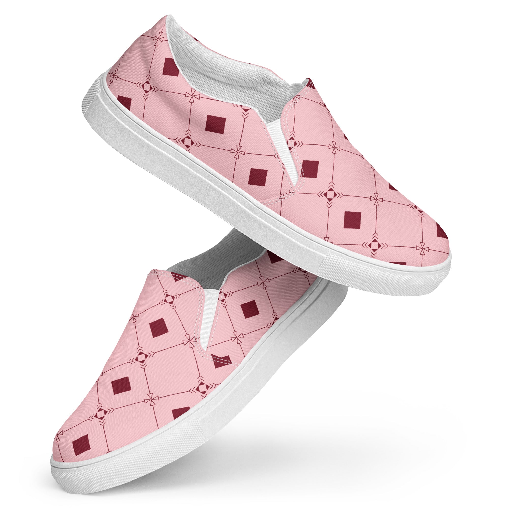 Ein Paar Damen Slip-on-Schuhe mit einem geometrischen Muster aus dunklen roten Quadraten und Linien auf einem hellrosa Hintergrund. Die Schuhe schweben vor einem weißen Hintergrund. Designed, by Just a Girl.