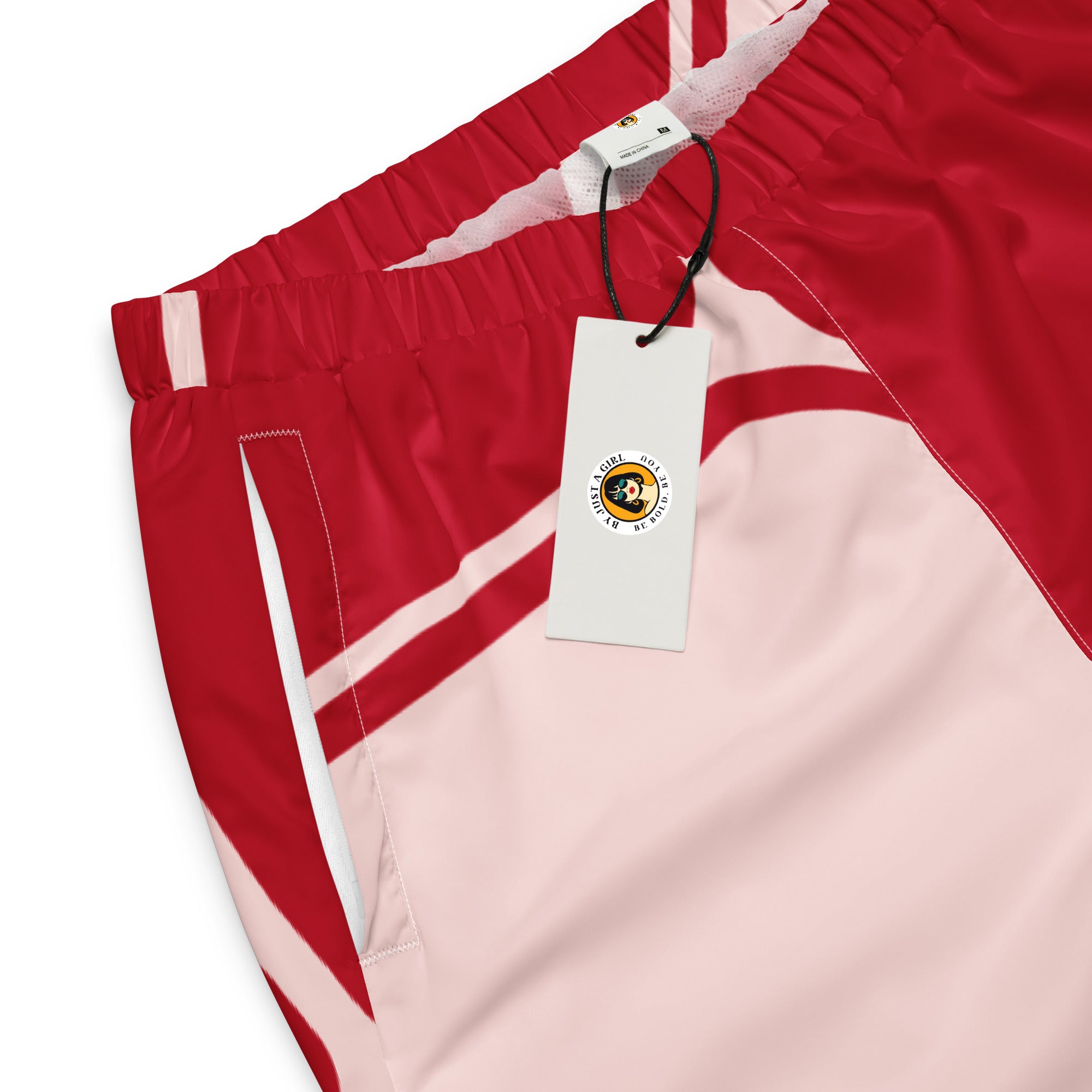 Damen Trainingshose in Rot und hellem Rosé mit einem abstrakten geometrischen Muster aus miteinander verbundenen, abgerundeten Rechtecken und Linien. Mockup Hosen Bund-und Taschenansicht mit Logo.  By Just a Girl.