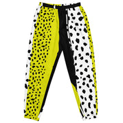 Eine Damen Trainingshose in Schwarz, Gelb und Weiß mit einem auffälligen, asymmetrischen Muster aus großen gelben Formen mit schwarzen Punkten, schwarzen Segmenten und weißen Bereichen mit schwarzen Punkten. Mockup Hosenansicht vorne. By Just a Girl.