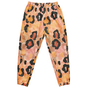 Die Damen Trainingshose mit einem abstrakten Leopardenmuster in Orange-, Rosa- und Schwarztönen. Hosenbund & Bein Abschluss mit elasitschen Bündchen. Mockup Hosen Vorderansicht. By Just a Girl.