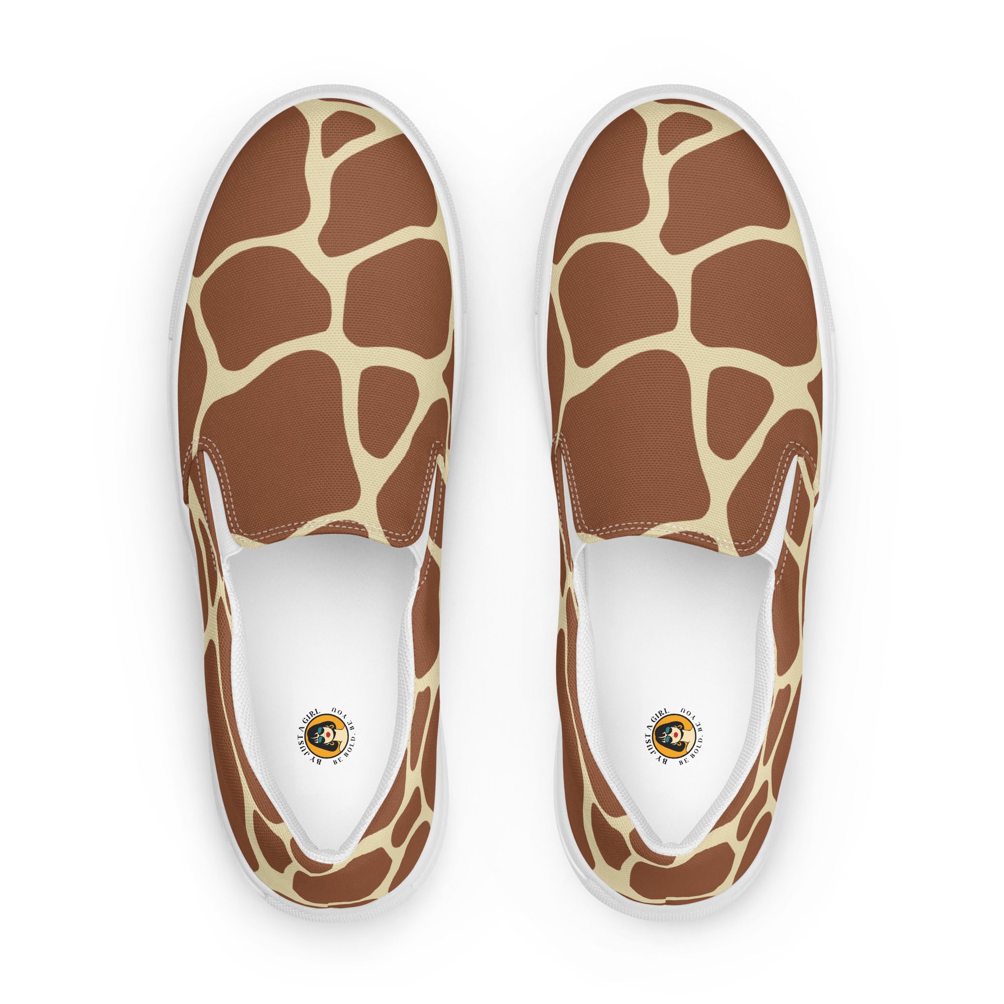 Ein Paar Damen Slip-on-Schuhe Ansicht von oben mit einem Giraffenmuster in Brauntönen und Creme auf einem hellen Hintergrund. Designed, by Just a Girl
