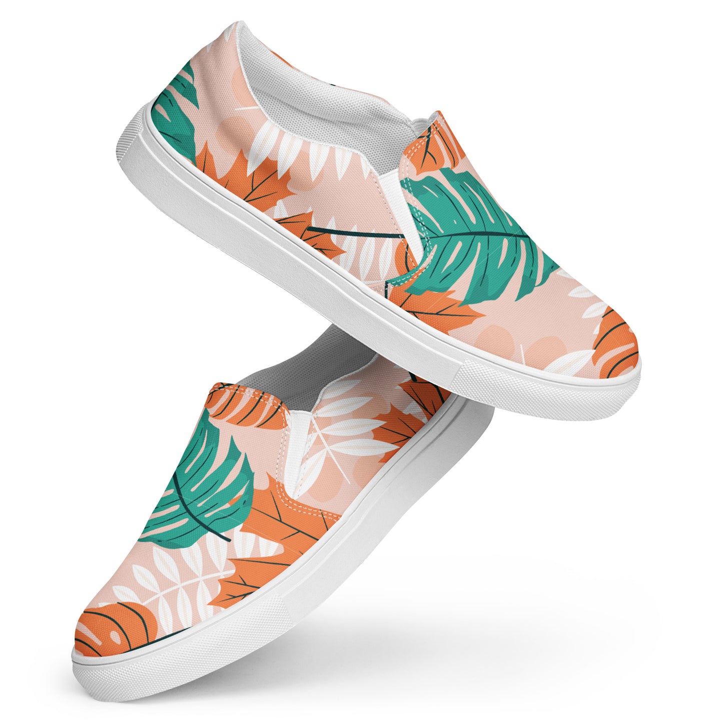 Ein Paar Damen Slip-on-Schuhe mit einem Blättermuster in Grün, herbstlichen Orange und Weiß auf einem pastell farbenen orangen Hintergrund. Die Schuhe schweben vor einem weißen Hintergrund. Designed, by Just a Girl.