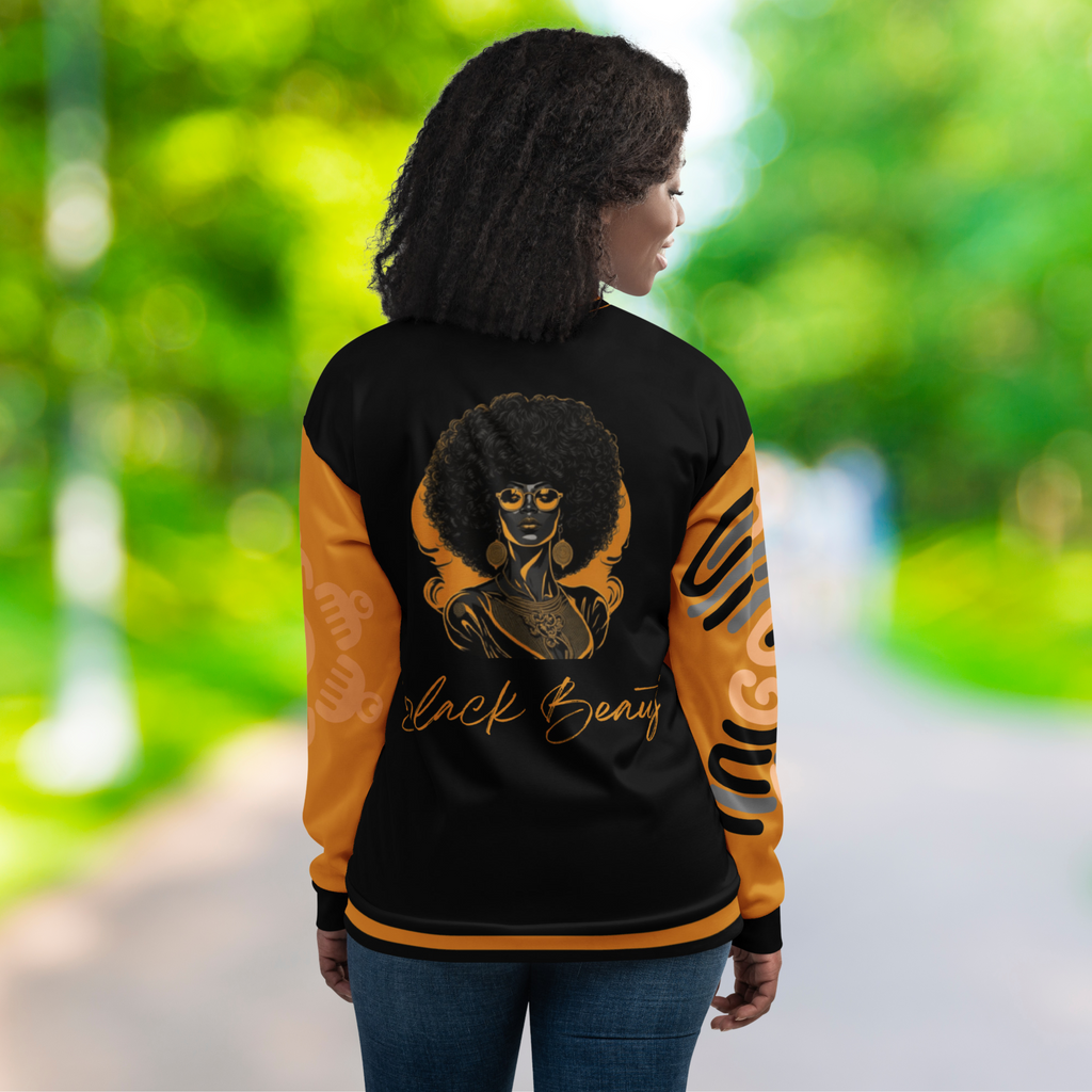 Das weibliche Model zeigt sich in der öffentlichkeit von der Rückseite mit der Jacke und präsentiert eine Afroamerikanische Frau auch in Schwarz Orange gehalten mit einer Schreibschrift darunter "Black Beauty".  Auf der rechten Seite des Ärmels ist die Afrikanische Landkarte aus abstrakten rhytmischen unregelmässigen Linien zu sehen. Auf dem Linkel Ärmel eine Blume aus Duafen Kämme dezent hinterlegt. Designed, by Just a Girl.
