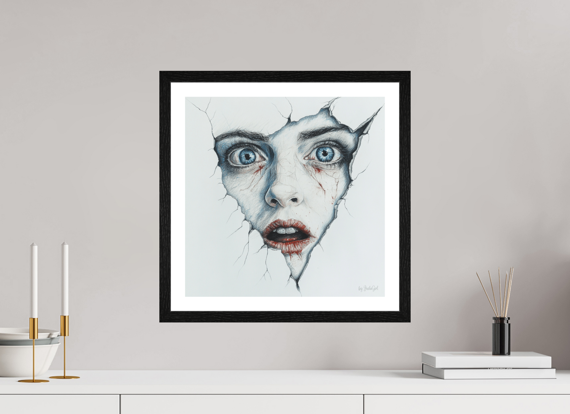 Das Kunstwerk "Die Maske fällt - Ich bin" zeigt ein Gesicht mit großen, blauen Augen und geöffnetem Mund, das durch eine rissige, weiße Oberfläche bricht. Um die Lippen und unter den Augen sind Blutflecken sichtbar. Das Bild ist in einem schwarzen Eichen Rahmen hängt als Wanddekoration oberhalt eines weißen Sideboards mit heller grau-beigen-wandfarbe.  Designed, by Just a Girl.