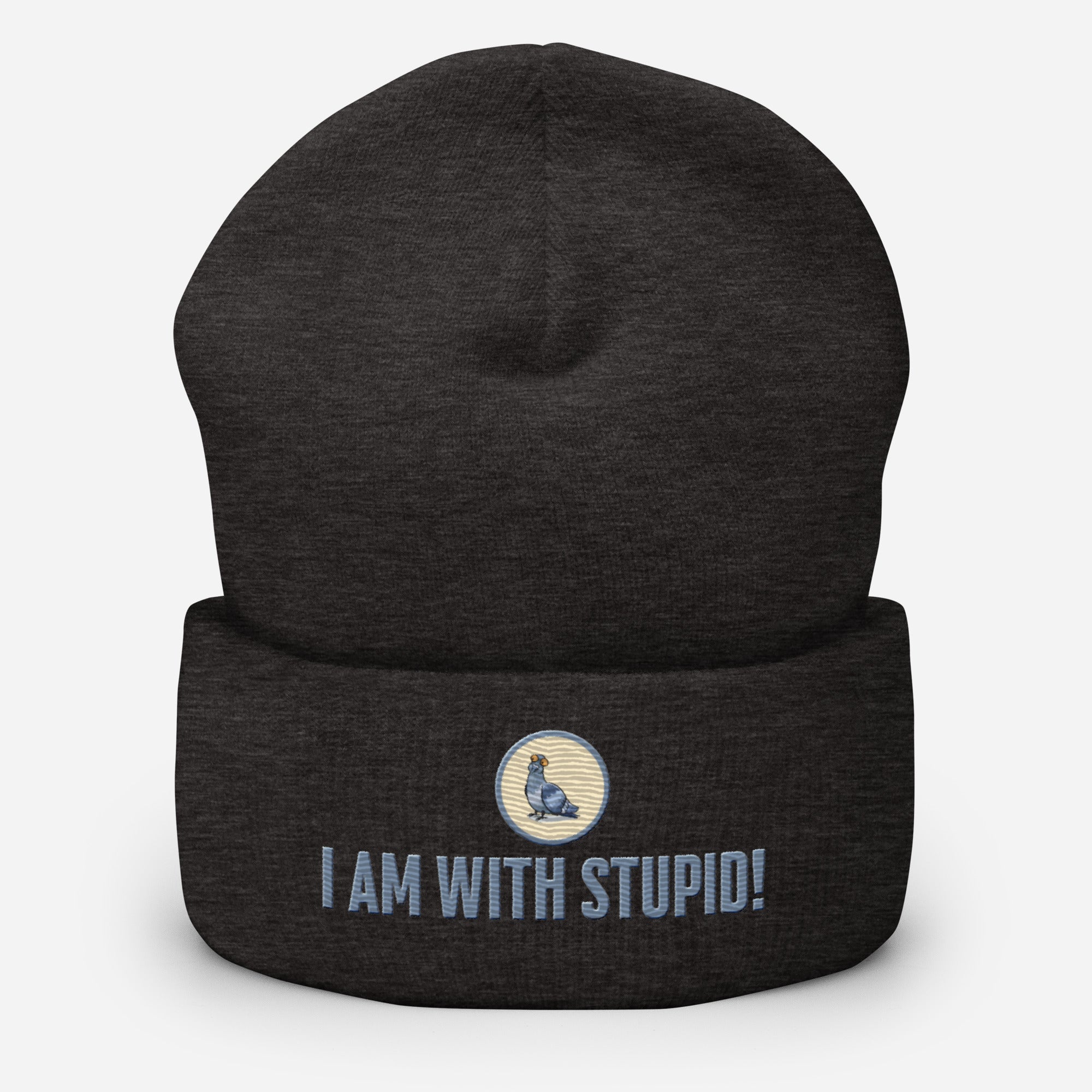 Eine dunkelgraue Cuffed Beanie mit aufgesticktem Patch als Taube mit einem runden beige-grauen Rahmen auf der Vorderseite. Darunter ein Schriftzug mit Grossgeschriebenen Buchstaben "I Am with Stupid!" Designed, by Just a Girl.