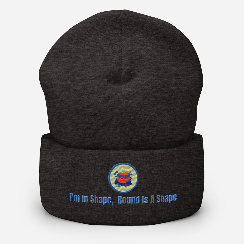 Ein dunkelgraues Cuffed Beanie mit einem aufgesticktem Patch eines Tomaten Superhleden (Cartoon) in einem Runden blau-salbeigrünem Rahmen sowie einen schlichten Schriftzug darunter der lautet: "I´m in Shape, Round is A Shape!" auf der Vorderseite. Designed, by Just a Girl.