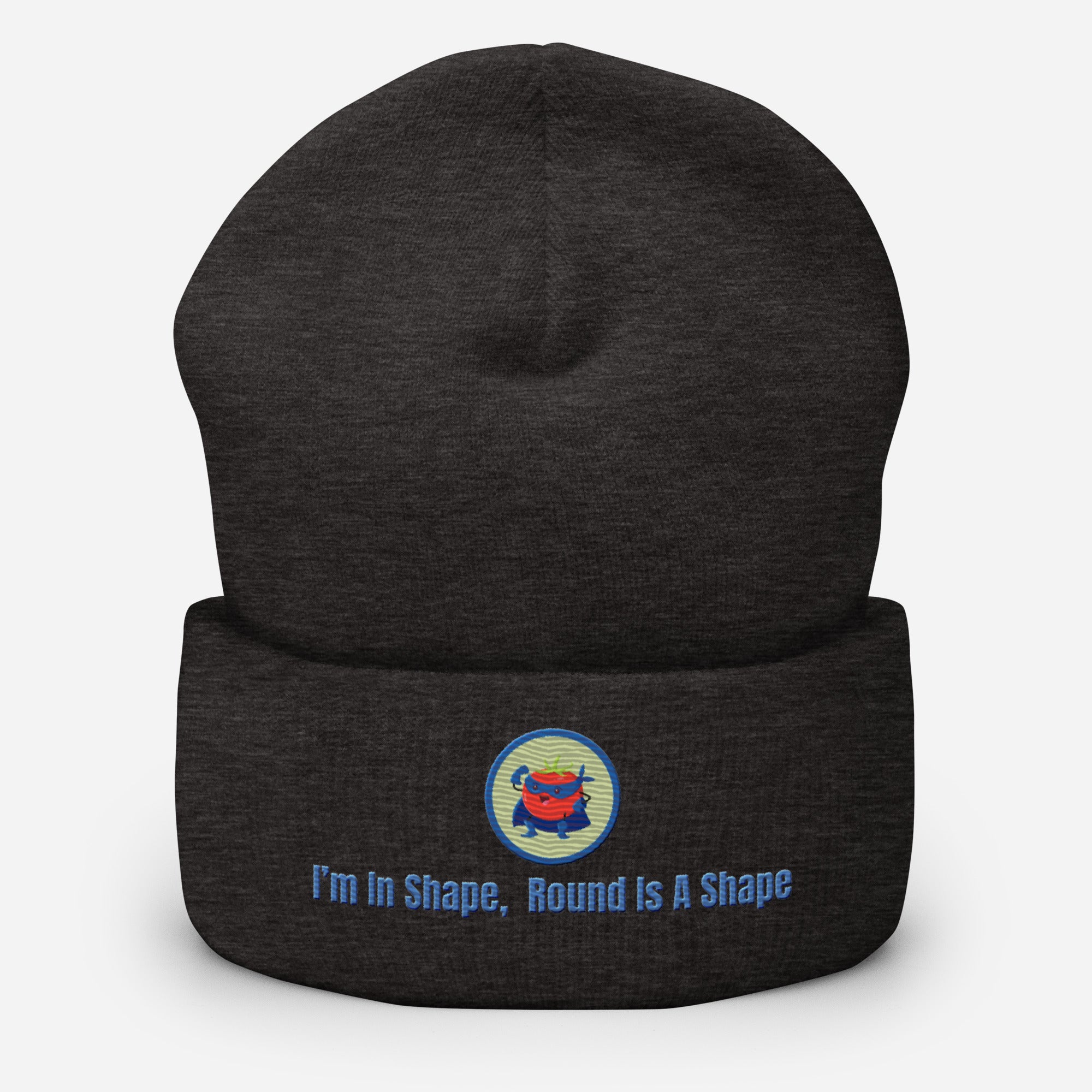 Ein dunkelgraues Cuffed Beanie mit einem aufgesticktem Patch eines Tomaten Superhleden (Cartoon) in einem Runden blau-salbeigrünem Rahmen sowie einen schlichten Schriftzug darunter der lautet: "I´m in Shape, Round is A Shape!" auf der Vorderseite. Designed, by Just a Girl.