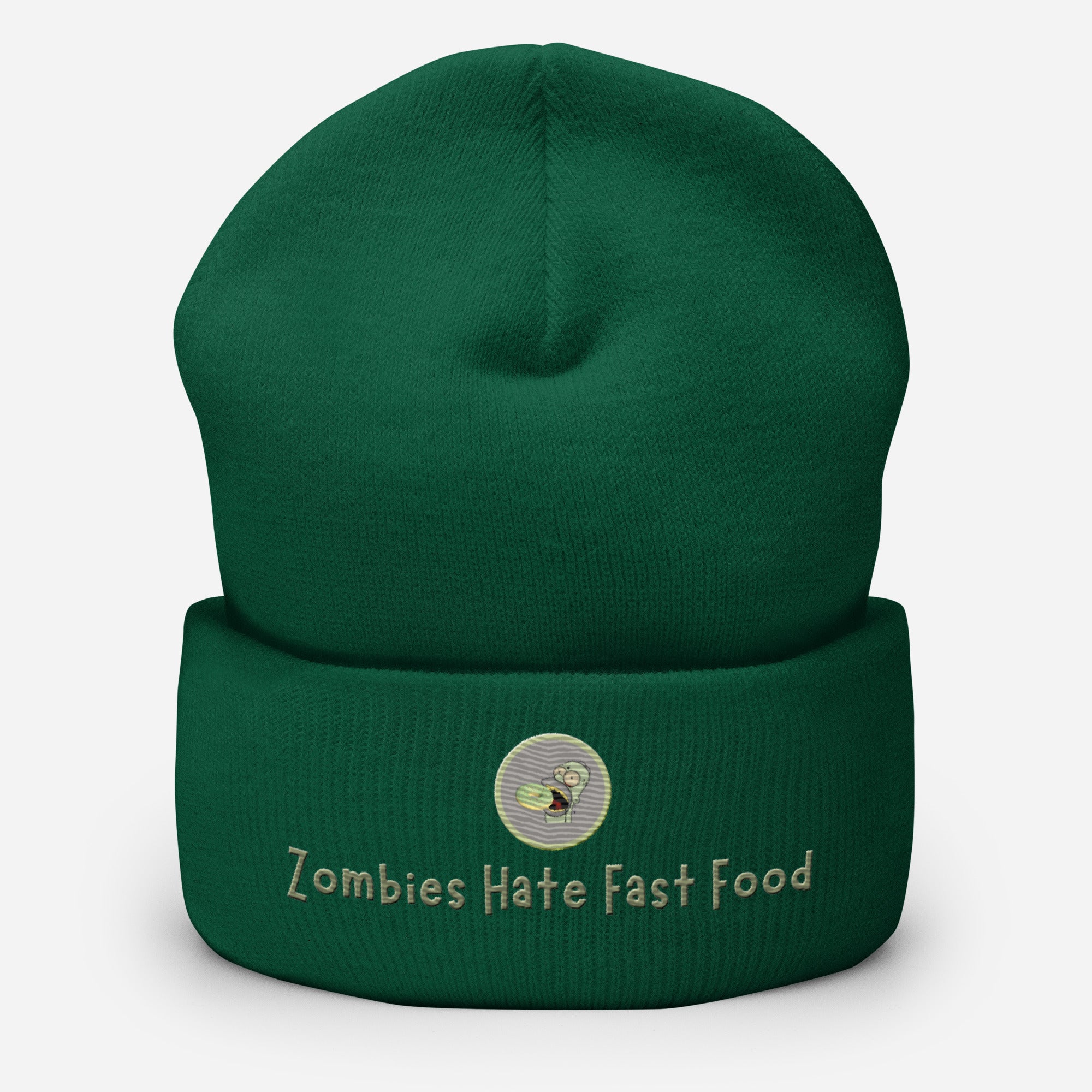 Ein Fichtengrünes Cuffed Beanie mit aufgesticktem Patch von Homer und einem Donut mit einem grau-salbei farbenen Rahmen sowie einen Schriftzug darunter mit dem Satz "Zombies Hate Fast Food!" auf der Vorderseite. Designed, by Just a Girl.