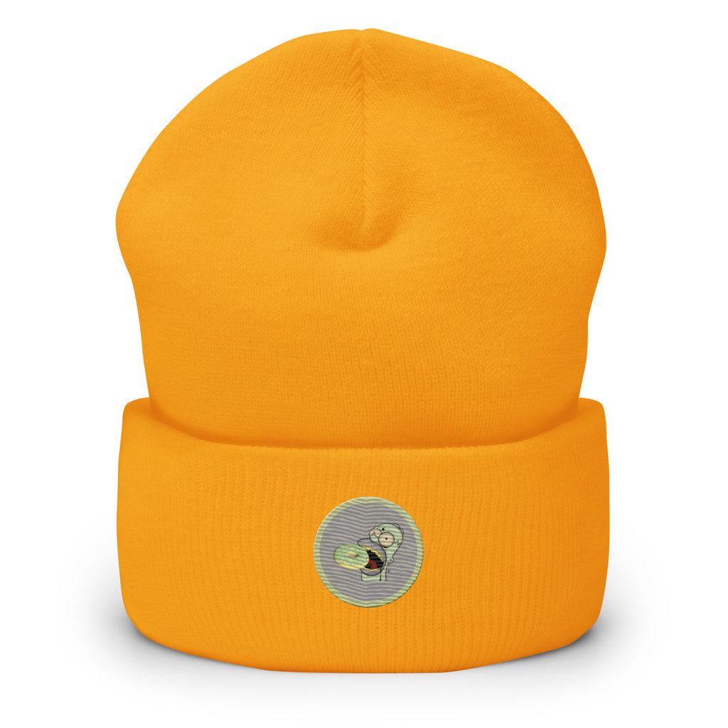 Ein Gold-gelbes Cuffed Beanie mit aufgesticktem Homer Monster Gesicht und einem Donut in einem hellgrauen-salbeigrünem Rahmen auf der Vorderseite. Designed, by Just a Girl.