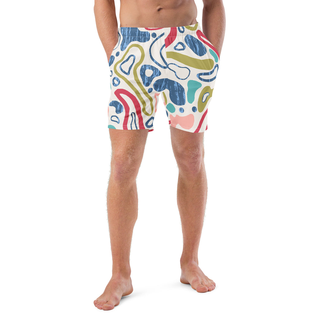 Eine weiße Badeshorts mit einem abstrakten, organischen Muster aus fließenden Linien und Formen in verschiedenen Farben wie Blau, Olivegrün, Rot, Türkis und hellem Rosa. Die Formen haben teilweise eine unregelmäßige, texturierte Füllung. Der Bund ist elastisch und überwiegend weiß mit einem Hauch von Rosa auf der rechten Seite.