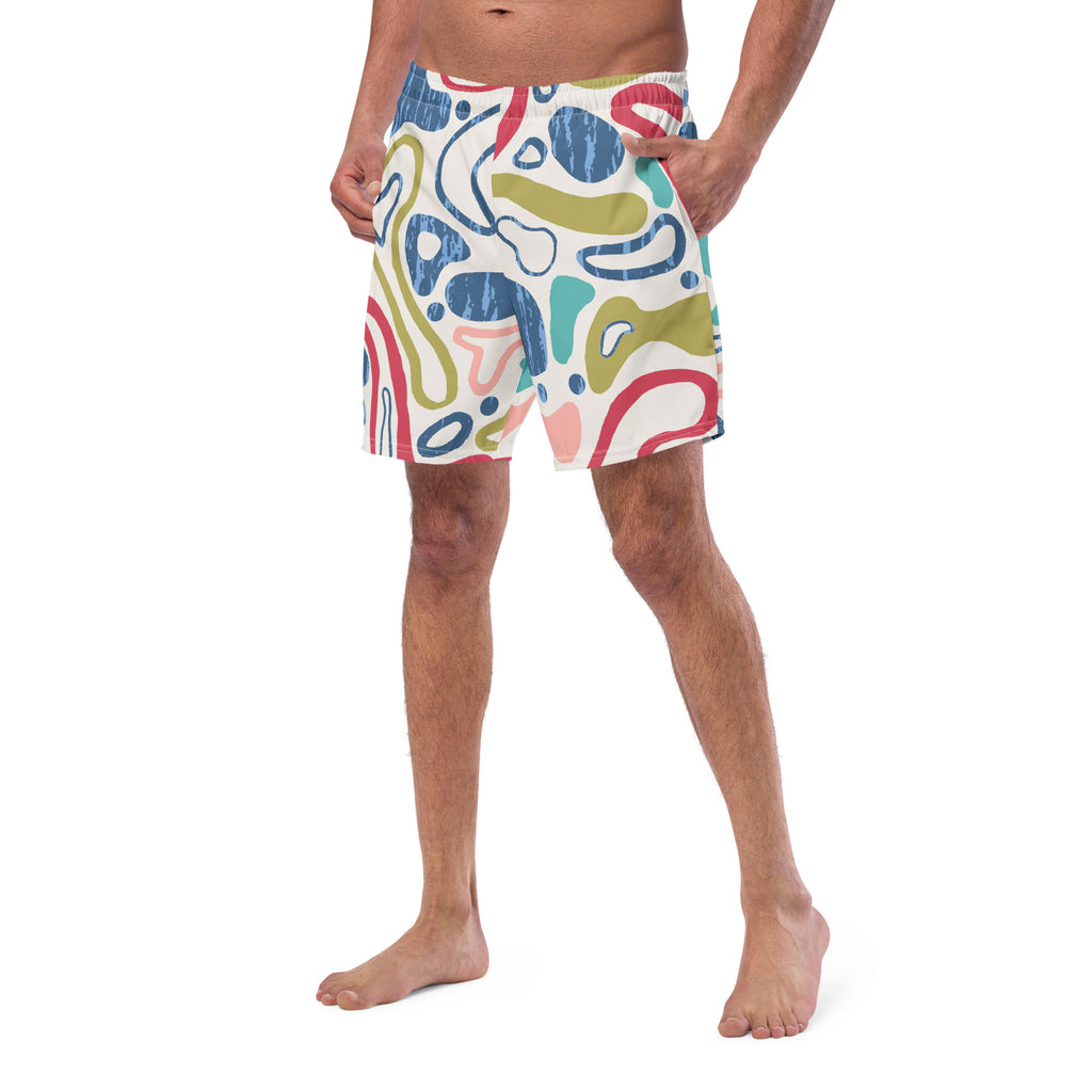 Eine weiße Badeshorts mit einem abstrakten, organischen Muster aus fließenden Linien und Formen in verschiedenen Farben wie Blau, Olivegrün, Rot, Türkis und hellem Rosa. Die Formen haben teilweise eine unregelmäßige, texturierte Füllung. Der Bund ist elastisch und überwiegend weiß mit einem Hauch von Rosa auf der rechten Seite.