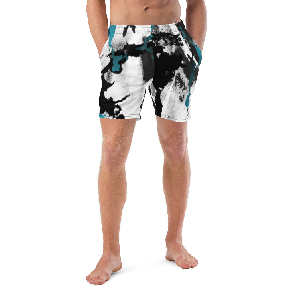 Eine weiße Badeshorts mit einem abstrakten, tintenfleckartigen Muster in Schwarz und leuchtendem Türkis. Der elastische Bund ist farblich passend abgesetzt.