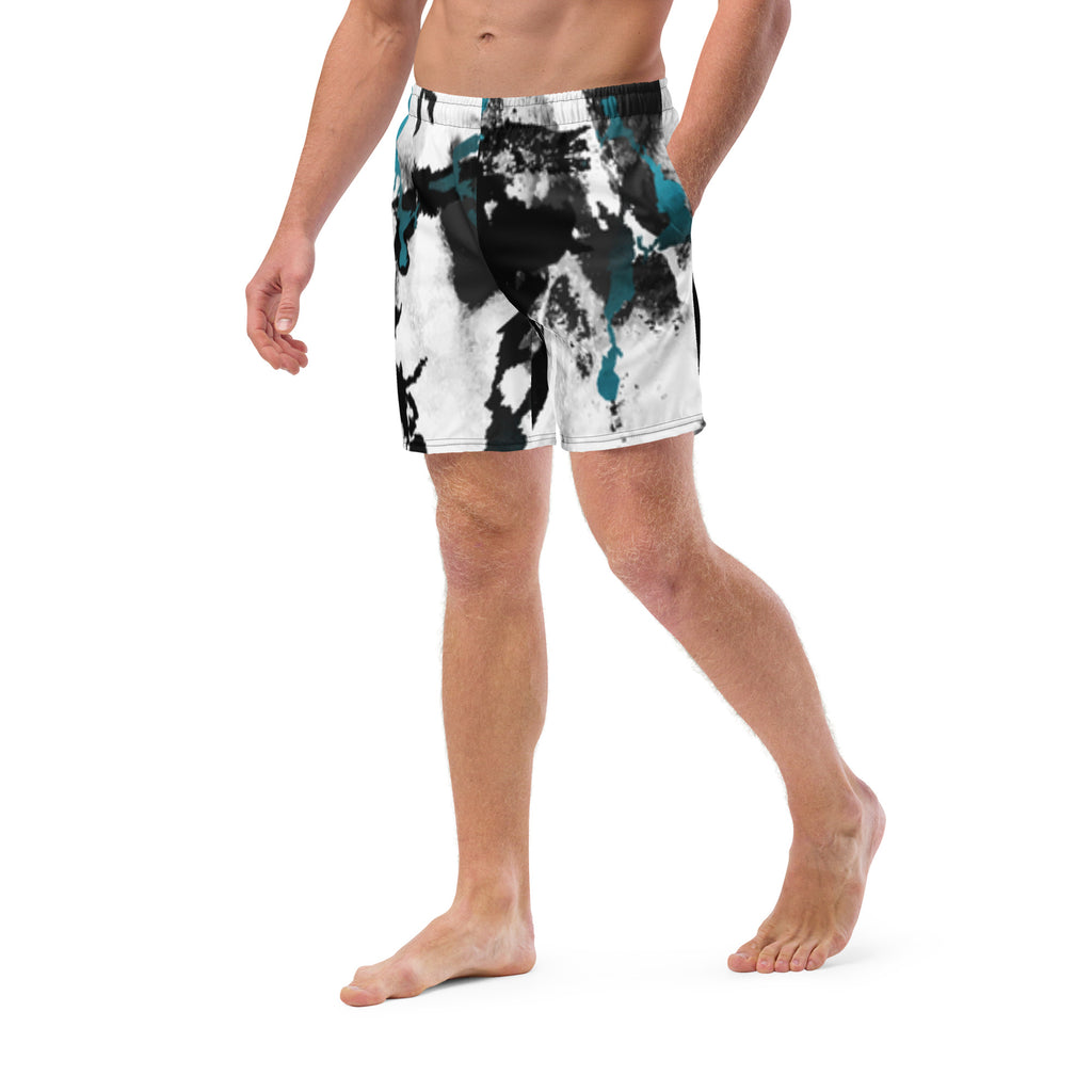 Eine weiße Badeshorts mit einem abstrakten, tintenfleckartigen Muster in Schwarz und leuchtendem Türkis. Der elastische Bund ist farblich passend abgesetzt.