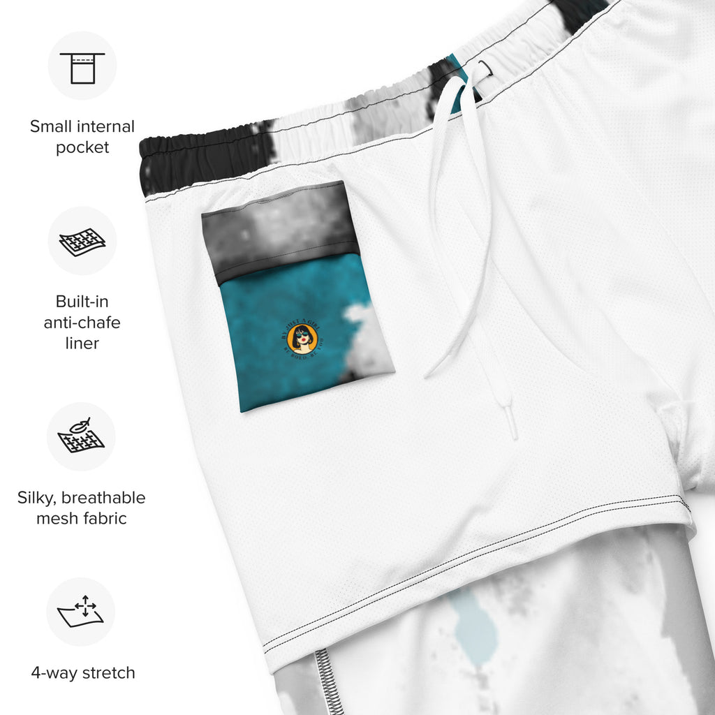 Eine weiße Badeshorts mit einem abstrakten, tintenfleckartigen Muster in Schwarz und leuchtendem Türkis. Der elastische Bund ist farblich passend abgesetzt.