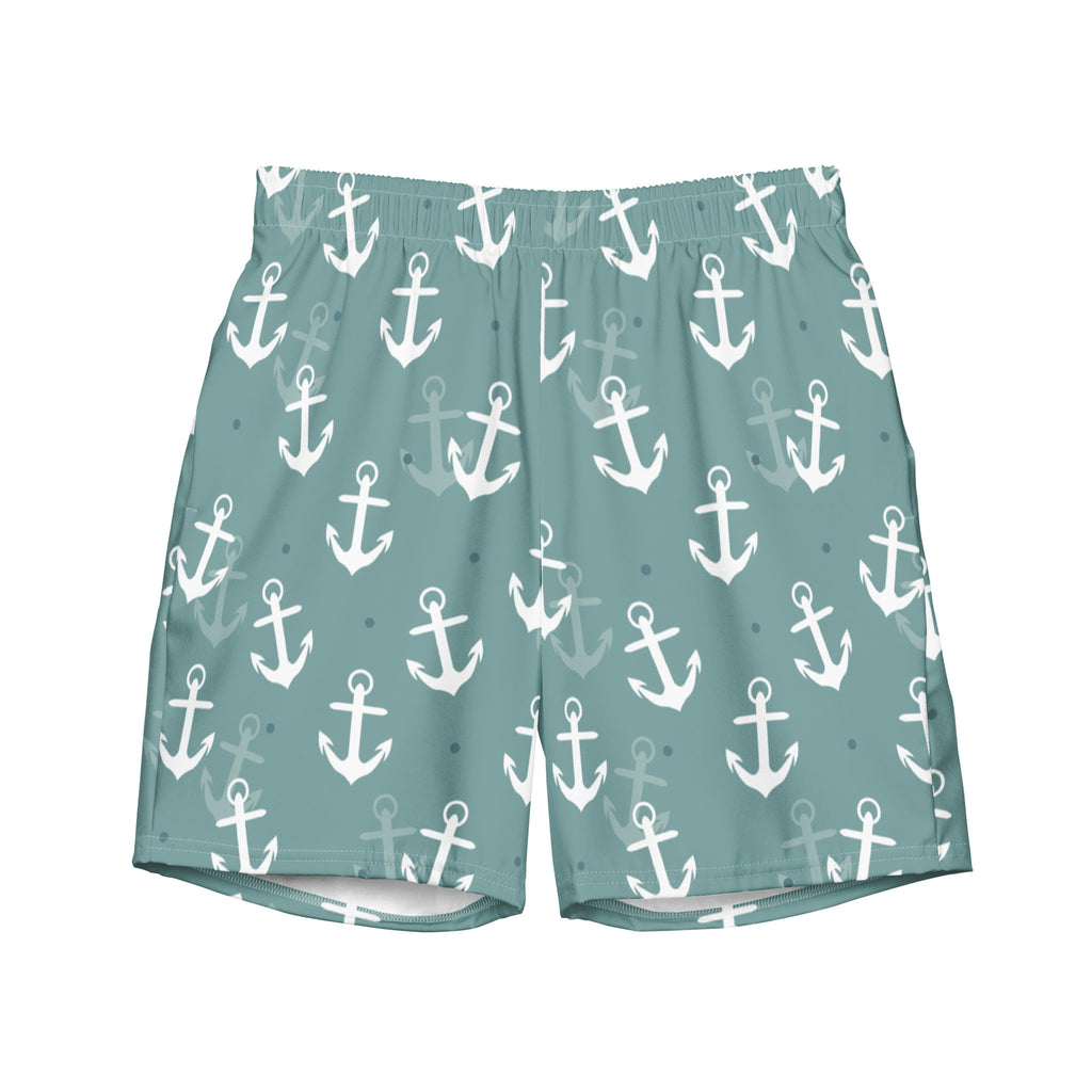 Eine Badeshorts in einem gedeckten Türkis- oder Blauton mit einem wiederkehrenden Muster aus weißen und hellgrauen Ankern und kleinen blauen Punkten. Der Bund ist elastisch und farblich passend.