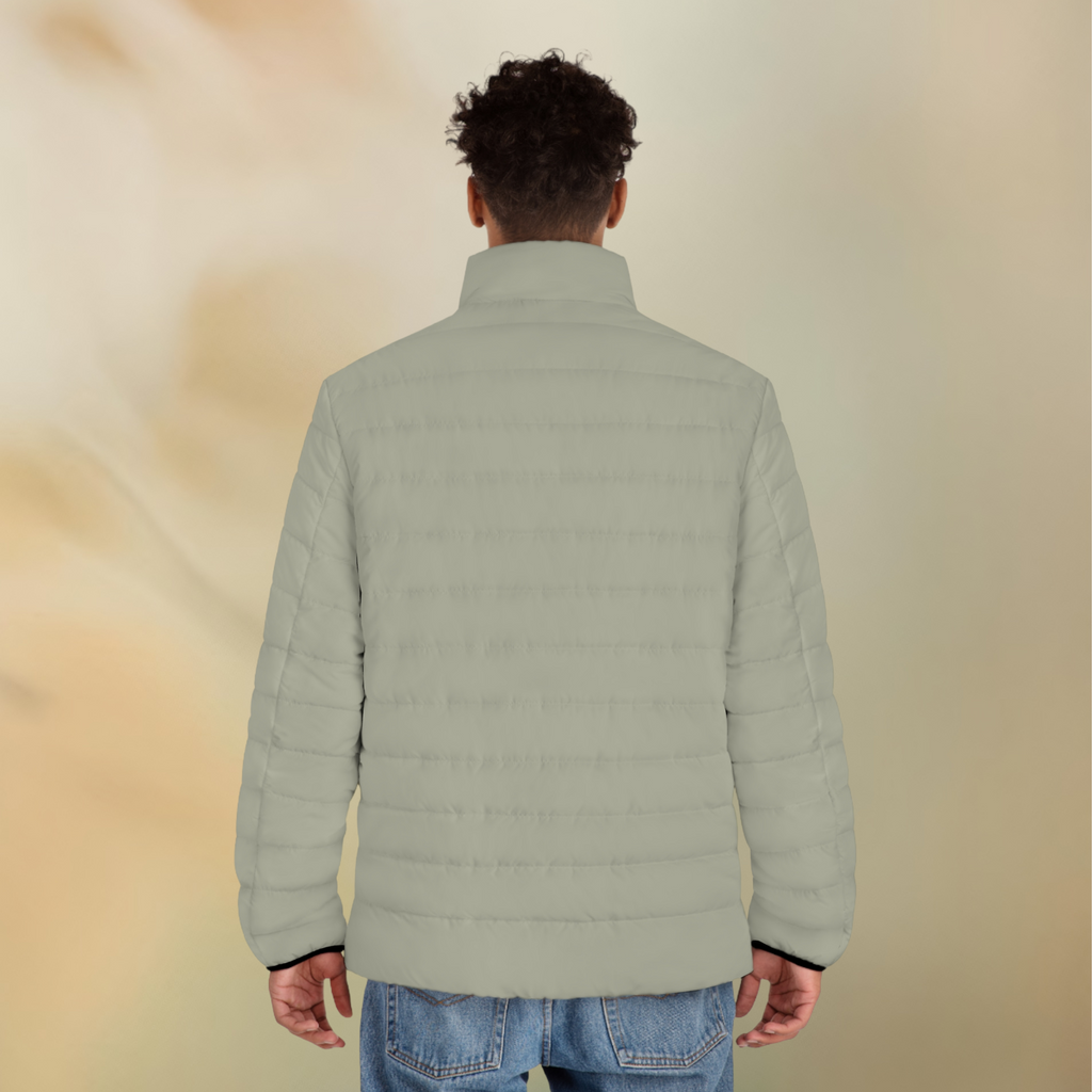 Ein männliches Model zeigt tragend mit der Rückenansicht die Herren-Pufferjacke  in einem Aschgrauen Farbton. Die Jacke ist horizontal gesteppt, hat eine glatte Oberfläche sowie einen hohen Stehkragen. Designed, by Just a Girl