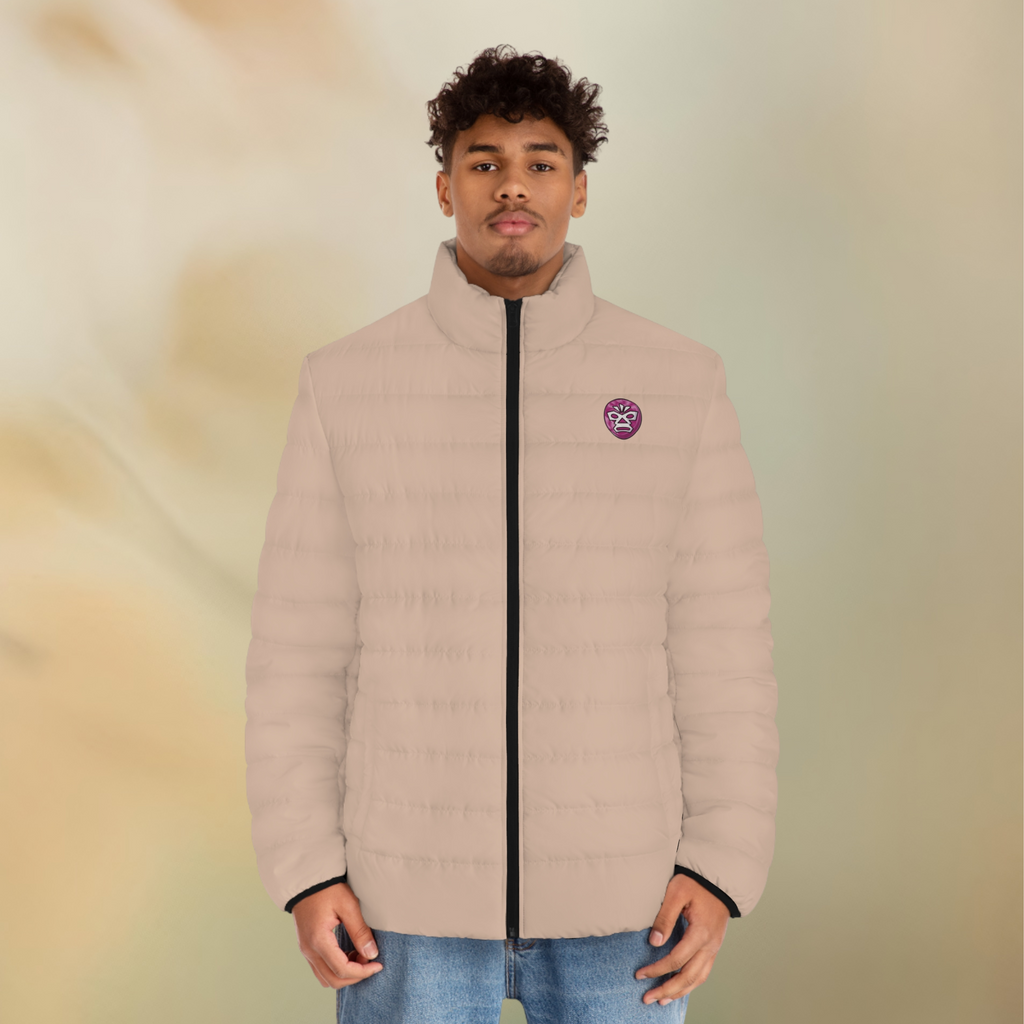 Ein männliclhes Modelt zeigt tragend die  Herren-Pufferjacke mit der Vorderansicht  in einem Wüstensand Farbton. Die Jacke ist horizontal gesteppt, hat eine glatte Oberfläche, einen hohen Stehkragen und einen durchgehenden Reißverschluss der Schwarz ist . Auf der linken Brusthöhe ist ein Emblem im Maori Stil. Designed, by Just a Girl

