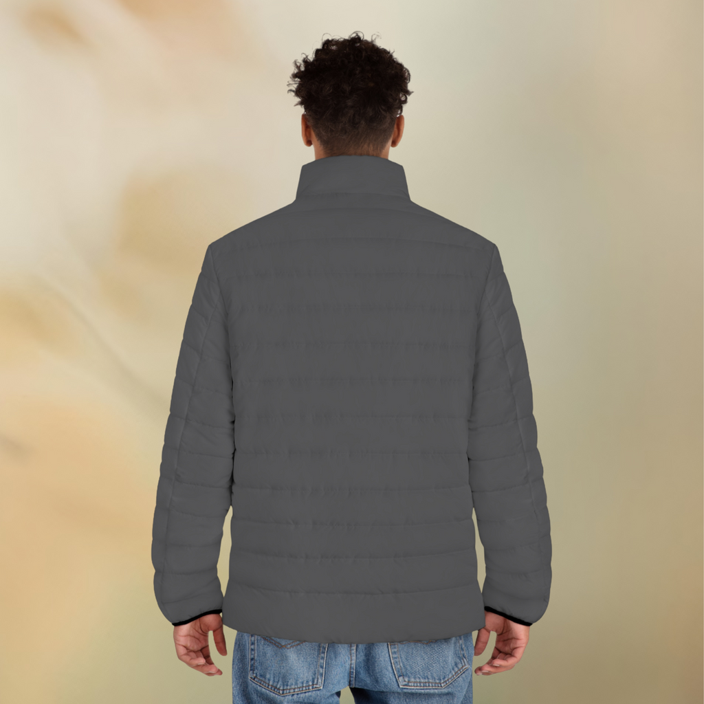 Ein männliches Model zeigt tragend von der Rückseite die Herren-Pufferjacke in einem Grey Stone Farbton. Die Jacke ist horizontal gesteppt, hat eine glatte Oberfläche sowie einen hohen Stehkragen. Designed, by Just a Girl

